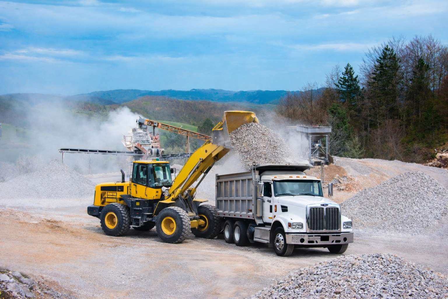 Heavy equipment loading construction materials at quarry